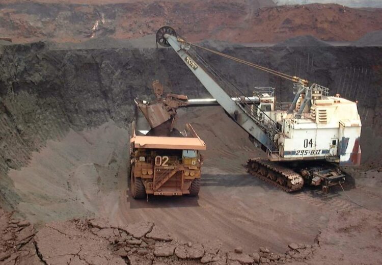 Escavadeira de mineração carregando caminhão fora de estrada em operação pesada